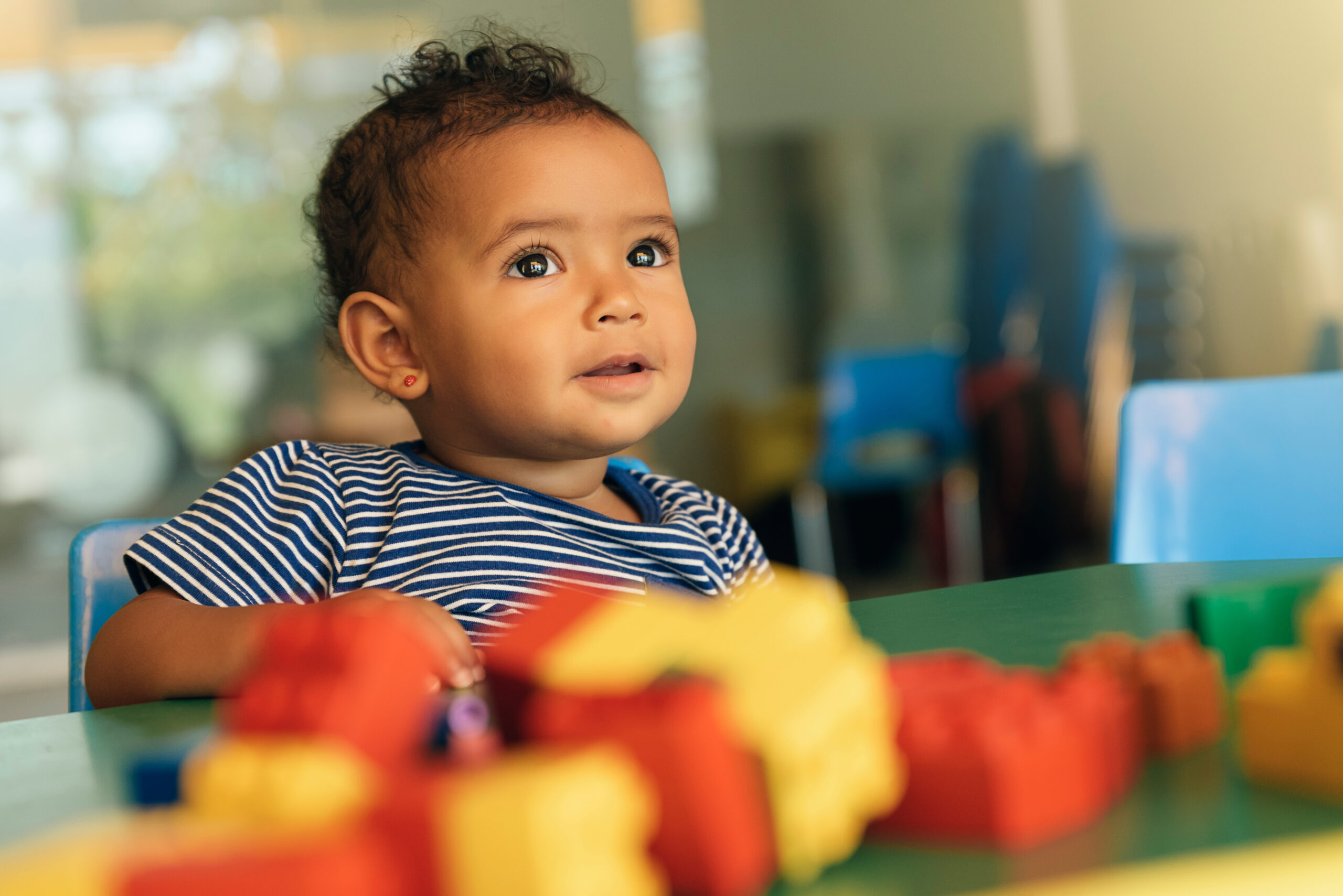 Happy baby playing with toy blocks.
